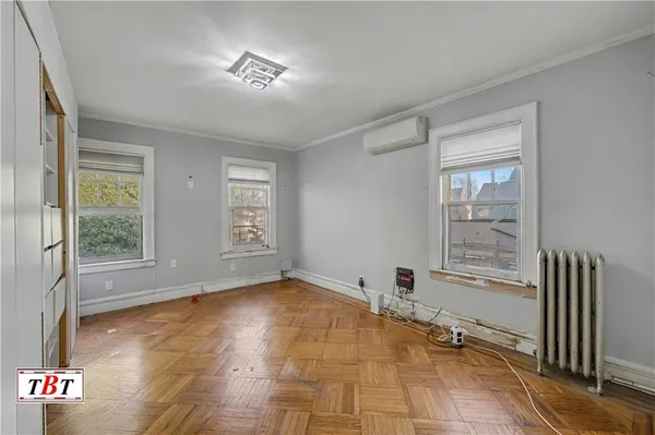 a view of an empty room with a window and a kitchen area