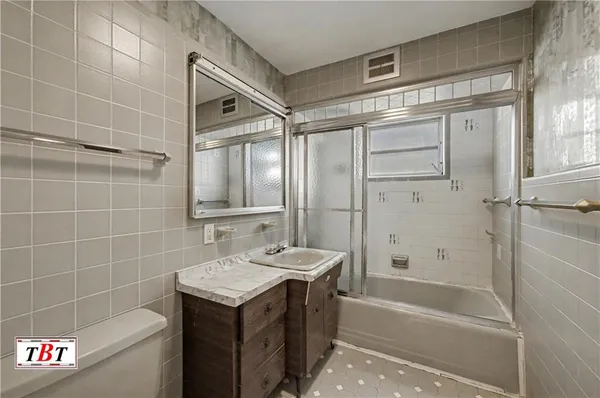 a bathroom with a granite countertop sink a toilet and shower