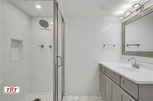 a bathroom with a sink a mirror and a shower