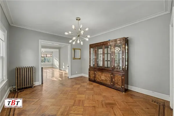 an empty room with floor to ceiling windows and chandelier