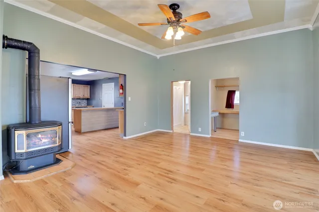 a view of an empty room with a window and a kitchen
