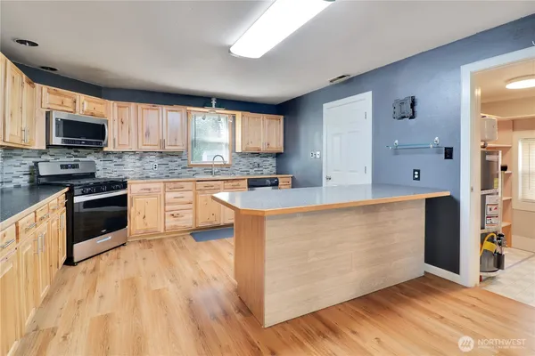 a kitchen with stainless steel appliances granite countertop a stove top oven a sink dishwasher and a refrigerator