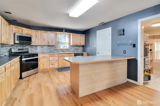 a kitchen with stainless steel appliances granite countertop a stove top oven a sink dishwasher and a refrigerator