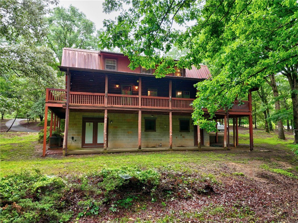 237 Spring Valley Road Liberty, SC 29657 - Photo 46 of 50 A charming cabin retreat, nestled amongst lush trees, offers a spacious multi-level deck for outdoor enjoyment.