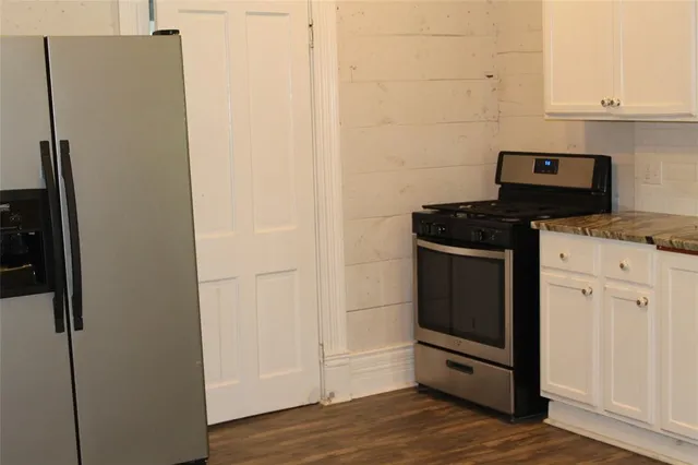 a kitchen with stainless steel appliances granite countertop a refrigerator and a stove
