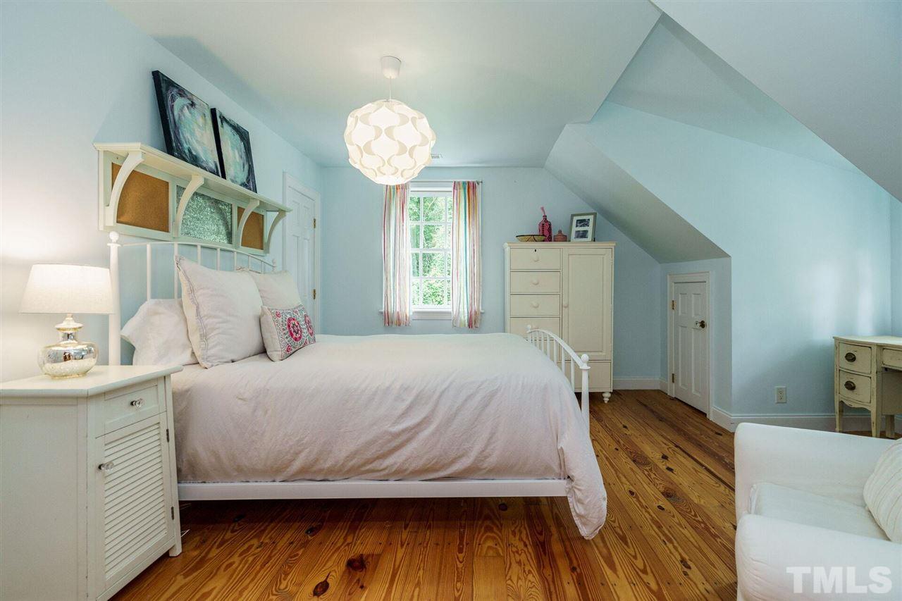503 Yarmouth Road Raleigh, NC 27608 - Photo 21 of 30 a bedroom with a bed and a chandelier