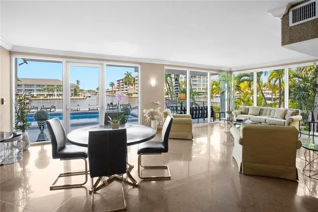 a dining room with furniture large windows and a livingroom
