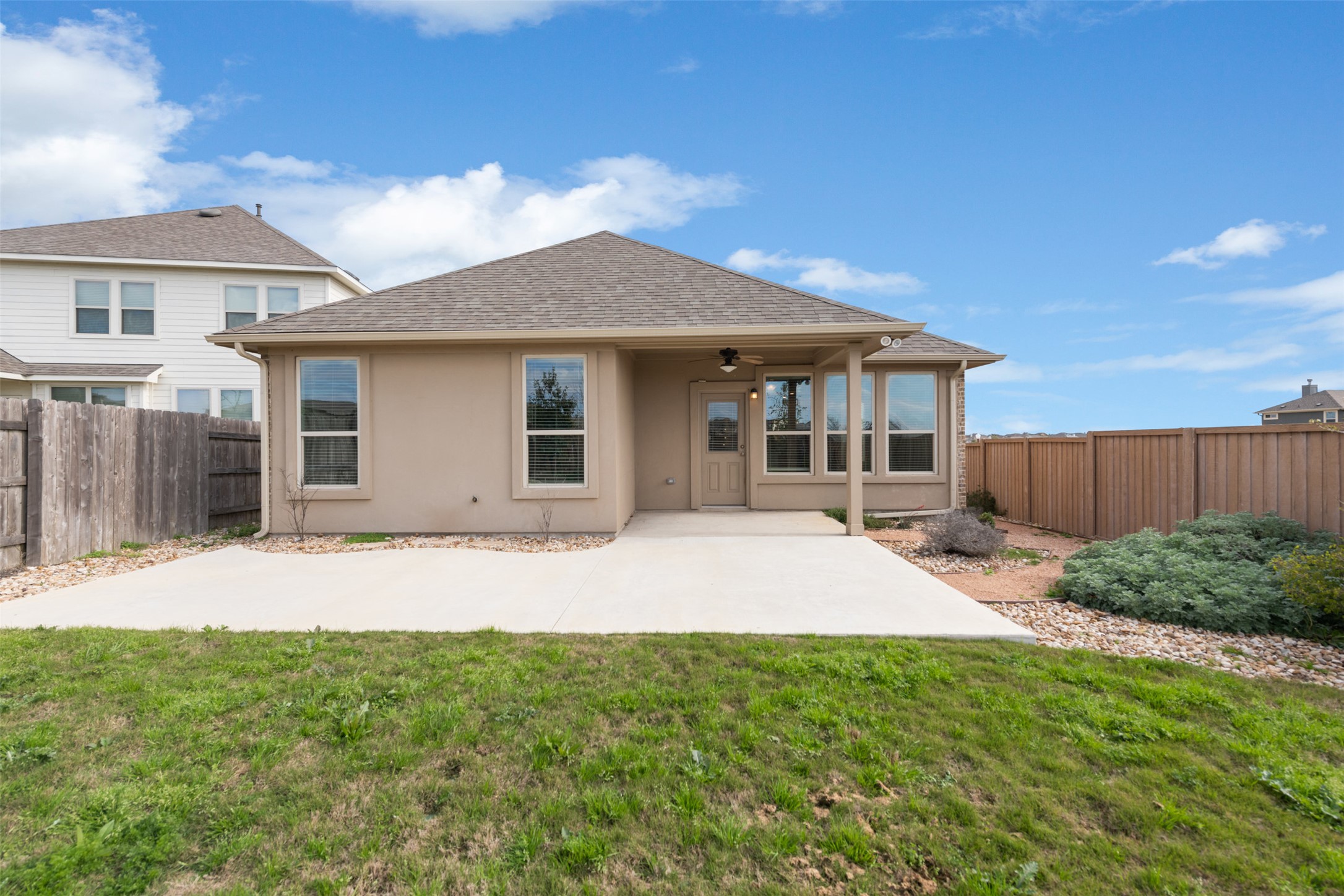 18304 Blush Rose Road Pflugerville, TX 78660 - Photo 16 of 16 An inviting covered patio sits alongside a flat concrete terrace in the fenced grassy yard.