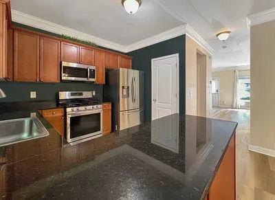 a kitchen with stainless steel appliances granite countertop a refrigerator a stove a sink and a microwave