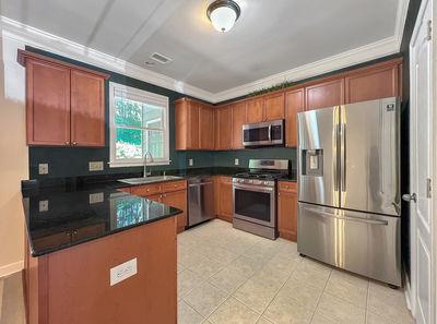 1232 Harris Commons Place, Unit 15 Roswell, GA 30076 - Photo 13 of 36 a kitchen with granite countertop a refrigerator stove top oven a sink and dishwasher