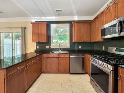 1232 Harris Commons Place, Unit 15 Roswell, GA 30076 - Photo 14 of 36 a kitchen with stainless steel appliances granite countertop a stove sink and cabinets