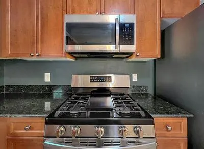 a stove top oven sitting inside of a kitchen
