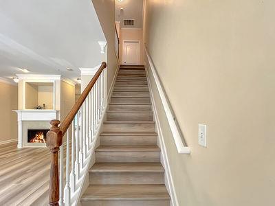 1232 Harris Commons Place, Unit 15 Roswell, GA 30076 - Photo 17 of 36 a view of staircase with lots of frames on wall and wooden floor