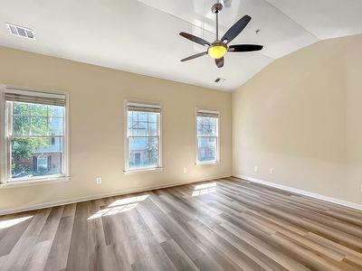 1232 Harris Commons Place, Unit 15 Roswell, GA 30076 - Photo 20 of 36 a view of an empty room with window and a chandelier fan