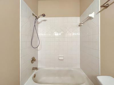 1232 Harris Commons Place, Unit 15 Roswell, GA 30076 - Photo 27 of 36 a bathroom with a bath tub with a shower