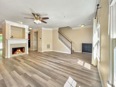 1232 Harris Commons Place, Unit 15 Roswell, GA 30076 - Photo 3 of 36 a view of a livingroom with a fireplace a ceiling fan and front door