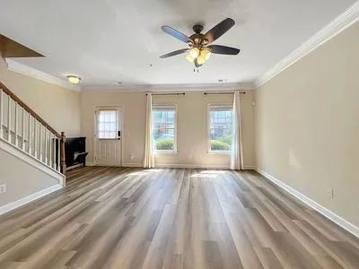 an empty room with wooden floor and windows