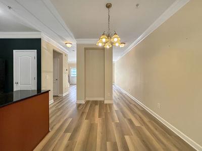 1232 Harris Commons Place, Unit 15 Roswell, GA 30076 - Photo 6 of 36 a view of a hallway with wooden floor and a chandelier