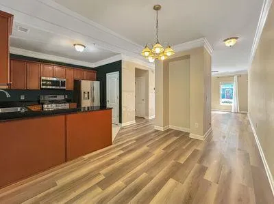 a view of a kitchen with a sink dishwasher a refrigerator with wooden floor