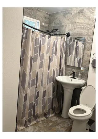 a bathroom with a sink toilet and shower