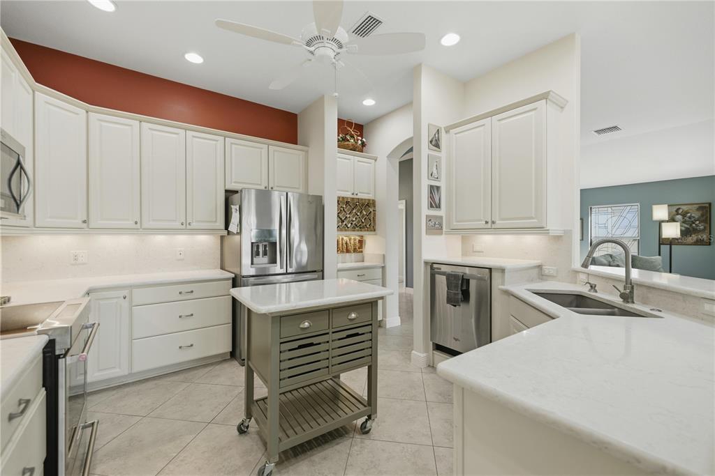 1016 Pickering Path The Villages, FL 32163 - Photo 17 of 38 a kitchen with granite countertop a sink stainless steel appliances and cabinets