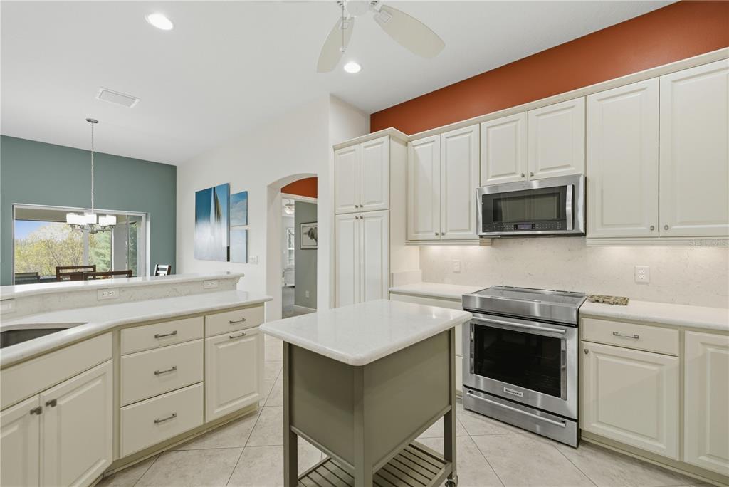 1016 Pickering Path The Villages, FL 32163 - Photo 18 of 38 a kitchen with white cabinets and stainless steel appliances