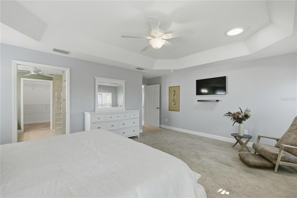 1016 Pickering Path The Villages, FL 32163 - Photo 20 of 38 a bedroom with a bed and a chandelier