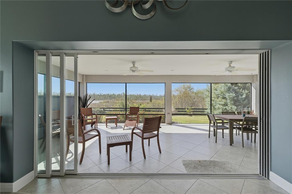 1016 Pickering Path The Villages, FL 32163 - Photo 27 of 38 a dining room with furniture and a floor to ceiling window