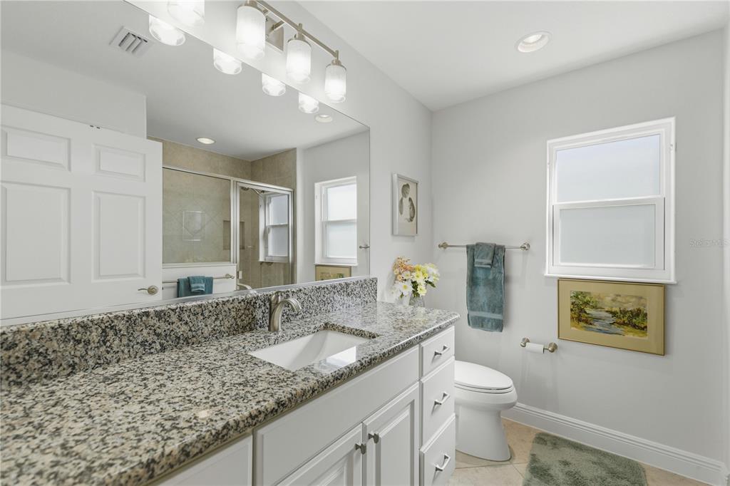 1016 Pickering Path The Villages, FL 32163 - Photo 7 of 38 a bathroom with a granite countertop sink a toilet and a mirror