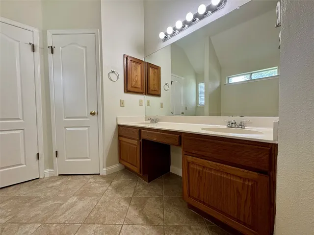 a bathroom with a double vanity sink a mirror and a bathtub