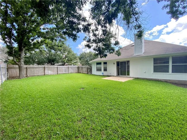 a view of a house with a backyard