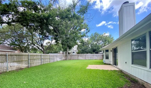 a view of yard with green space and wooden fence