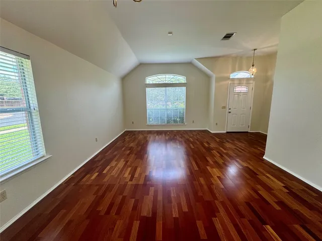 a view of a room with wooden floors and window