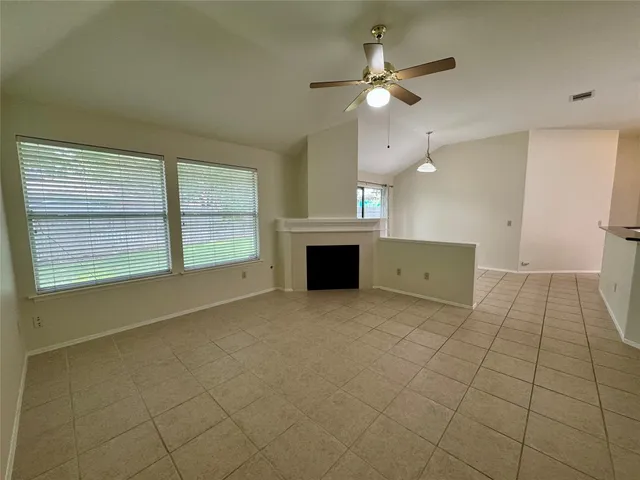 an empty room with fireplace and windows