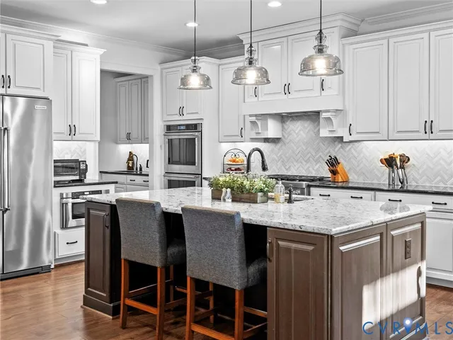 a kitchen with stainless steel appliances granite countertop a white cabinets and a stove