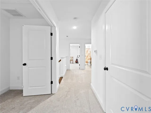 a view of a hallway with a furniture and a refrigerator