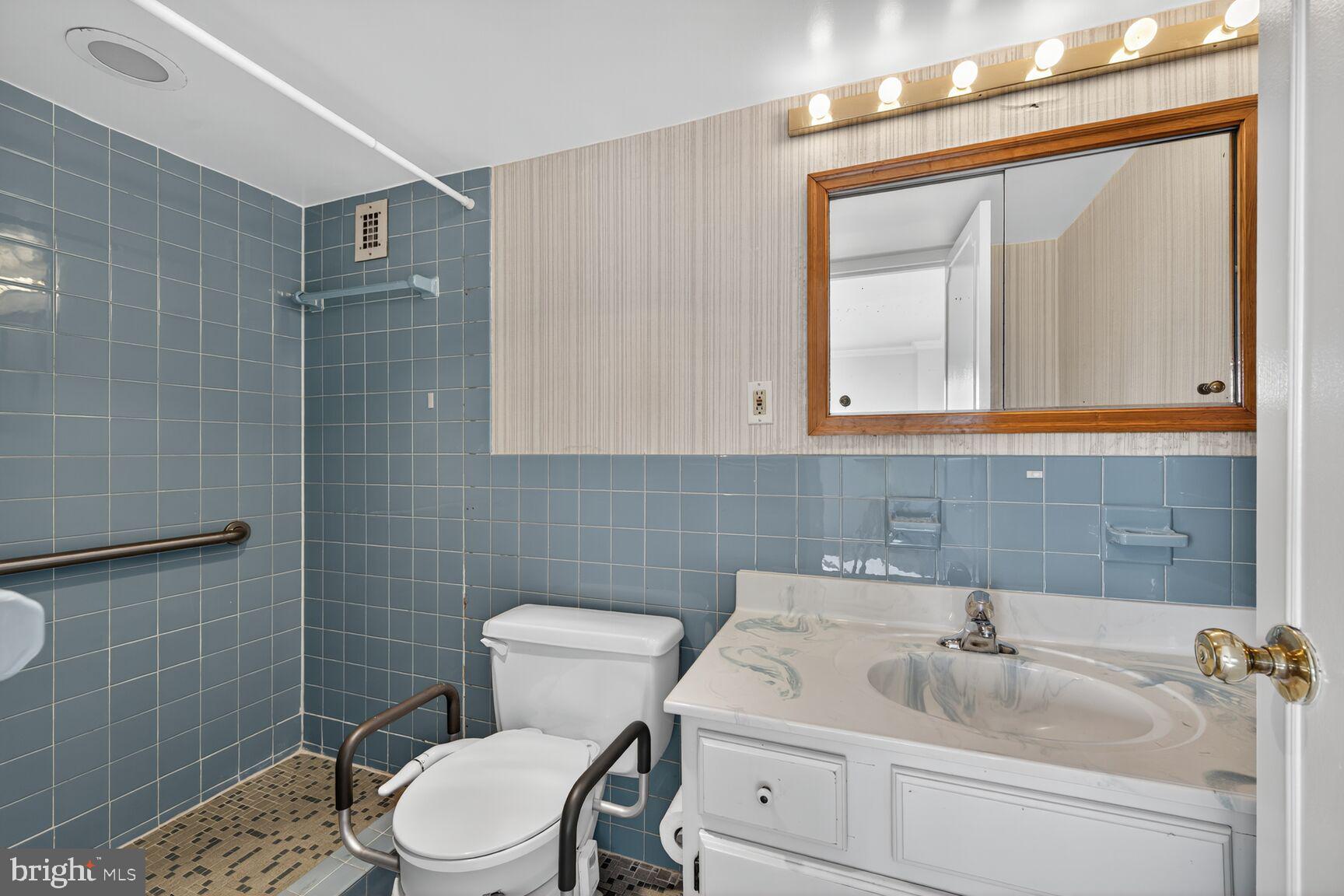 1111 University Boulevard West, Unit 1016 & 1017 Silver Spring, MD 20902 - Photo 11 of 38 a bathroom with a sink a toilet and mirror