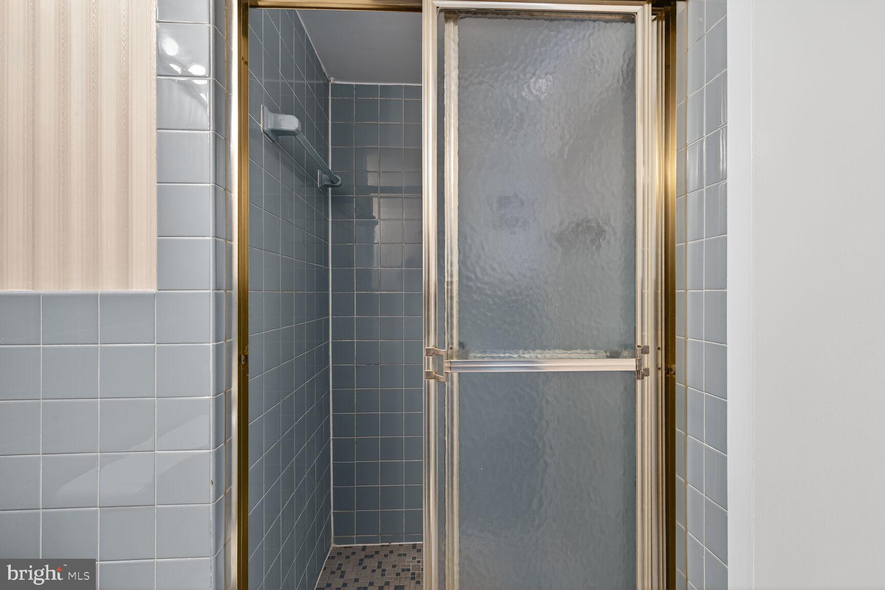 1111 University Boulevard West, Unit 1016 & 1017 Silver Spring, MD 20902 - Photo 16 of 38 a bathroom with a glass shower door