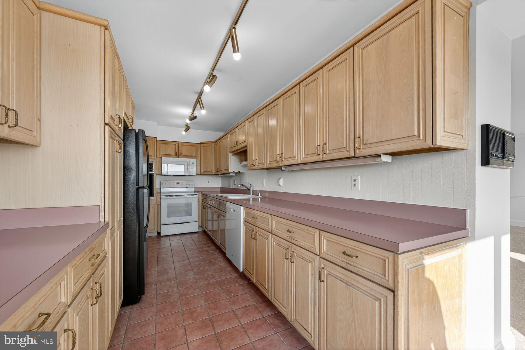 1111 University Boulevard West, Unit 1016 & 1017 Silver Spring, MD 20902 - Photo 3 of 38 a kitchen with cabinets and white appliances