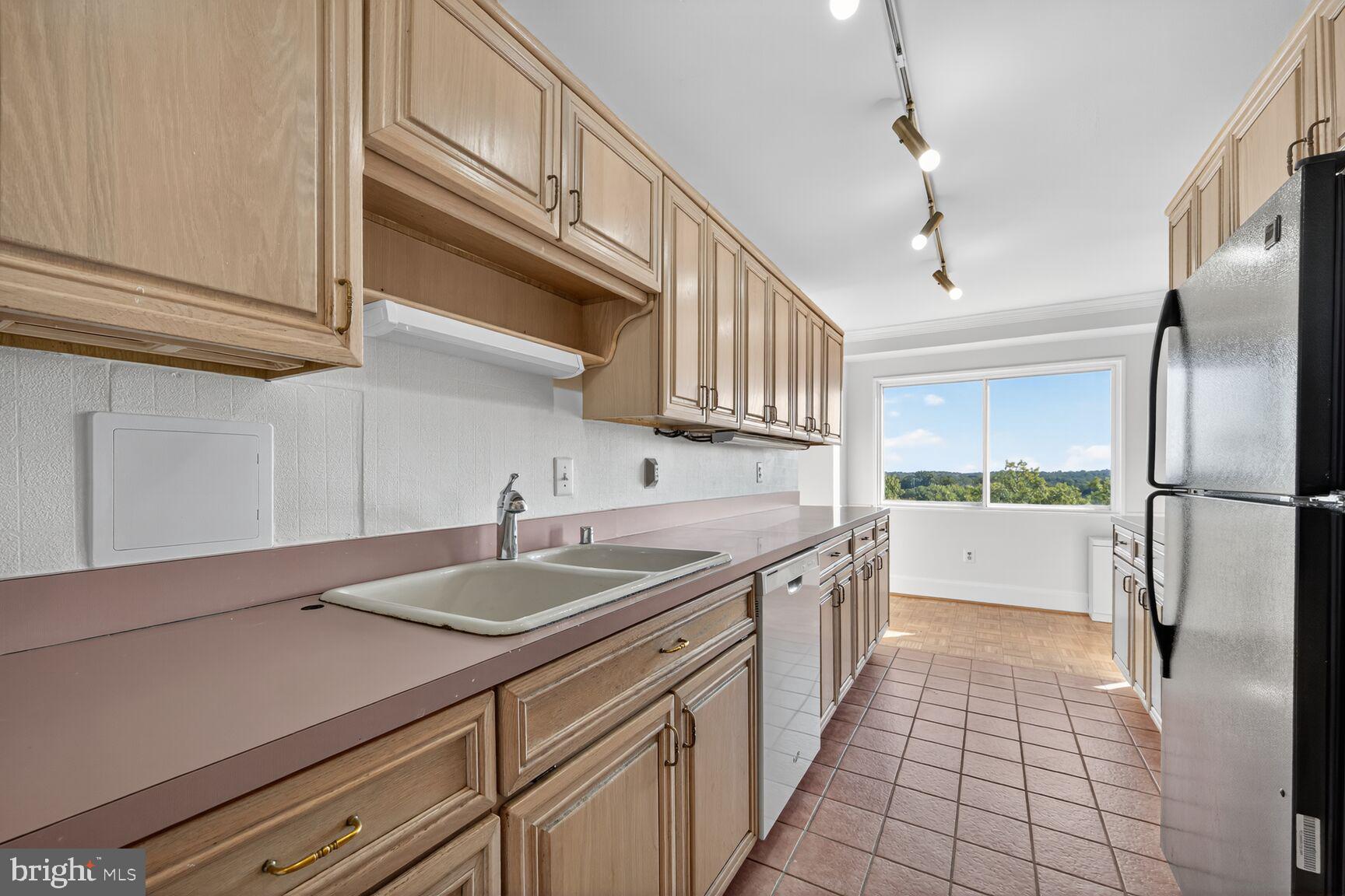 1111 University Boulevard West, Unit 1016 & 1017 Silver Spring, MD 20902 - Photo 4 of 38 a kitchen with a sink and refrigerator