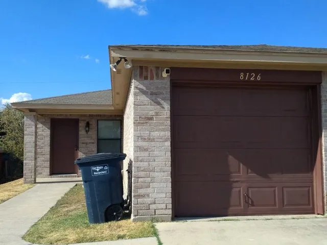 a view of backyard with wooden fence and large trees