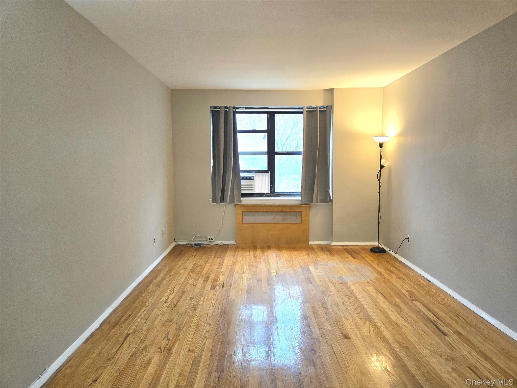 138-18 28th Road, Unit 2F Queens, NY 11354 - Photo 6 of 13 a view of an empty room with wooden floor and a window