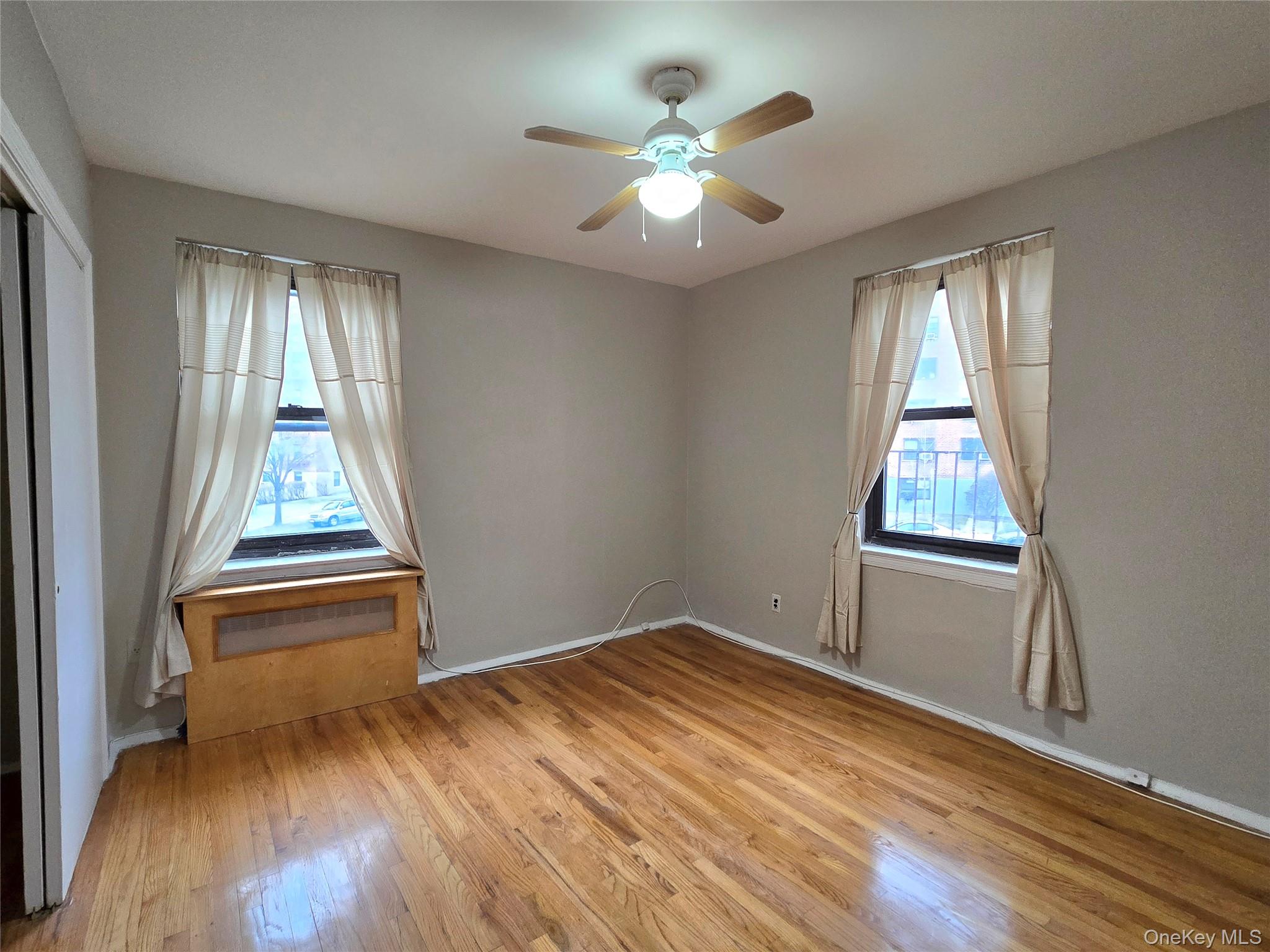 138-18 28th Road, Unit 2F Queens, NY 11354 - Photo 7 of 13 wooden floor in an empty room with a window