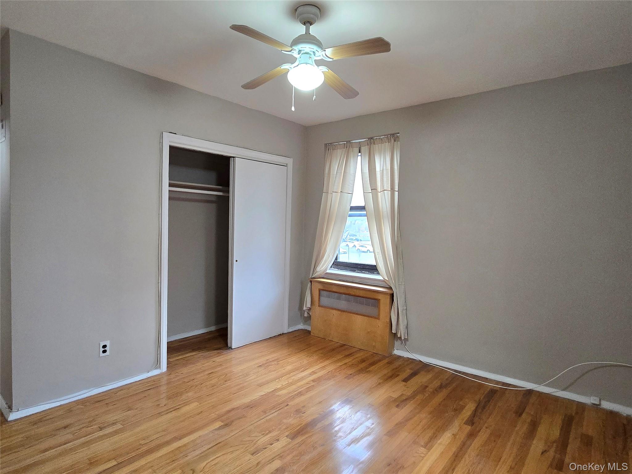 138-18 28th Road, Unit 2F Queens, NY 11354 - Photo 8 of 13 wooden floor in an empty room with a window