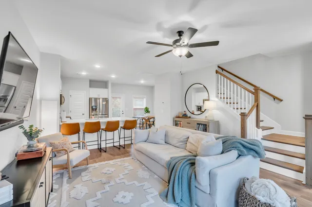 a living room with furniture kitchen view and a chandelier