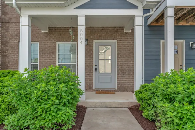 a living room with furniture a flat screen tv and kitchen view