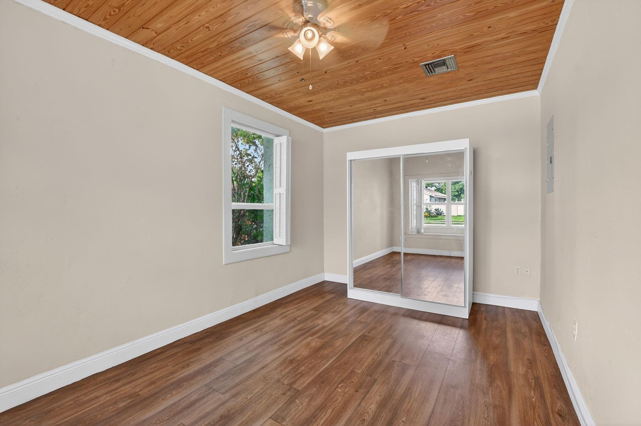 501 Northwest 54th Street Boca Raton, FL 33487 - Photo 13 of 44 an empty room with wooden floor chandelier and windows