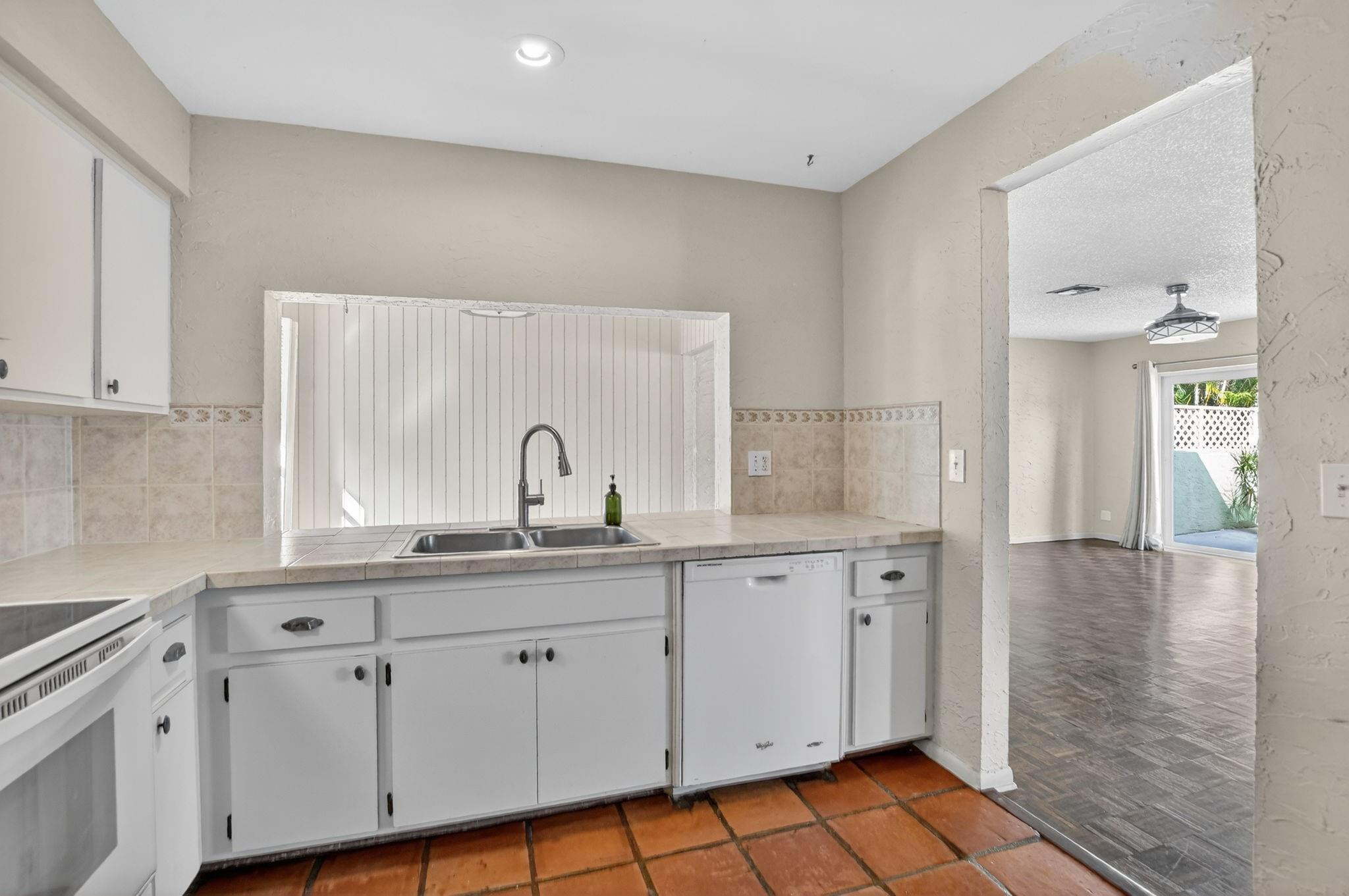 501 Northwest 54th Street Boca Raton, FL 33487 - Photo 14 of 44 a kitchen with white cabinets appliances and a sink