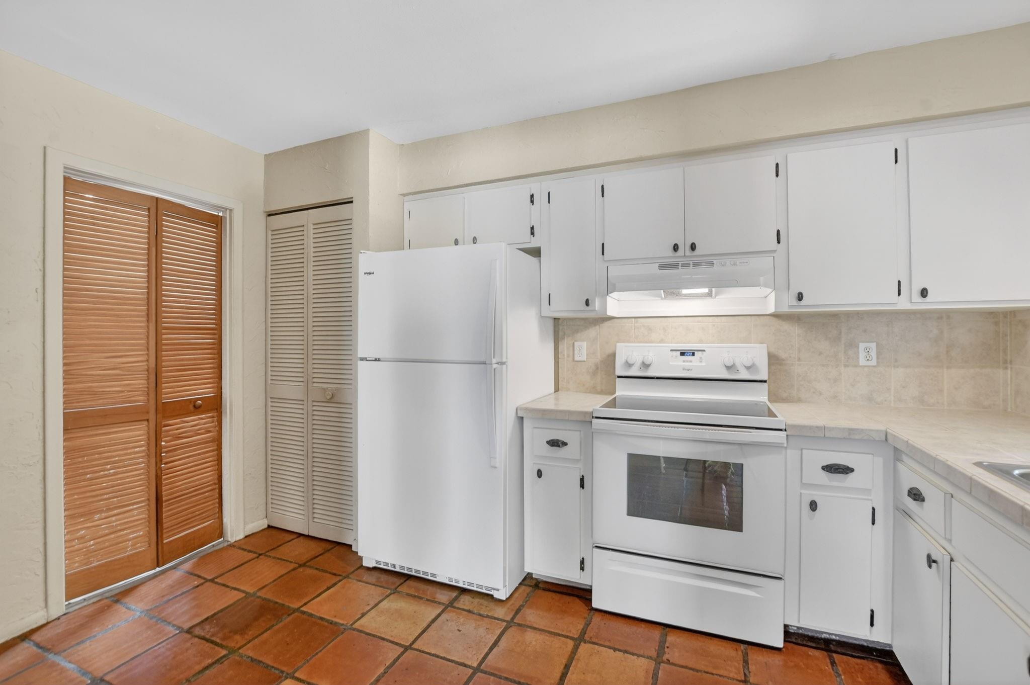 501 Northwest 54th Street Boca Raton, FL 33487 - Photo 15 of 44 a white refrigerator freezer and a stove in a kitchen