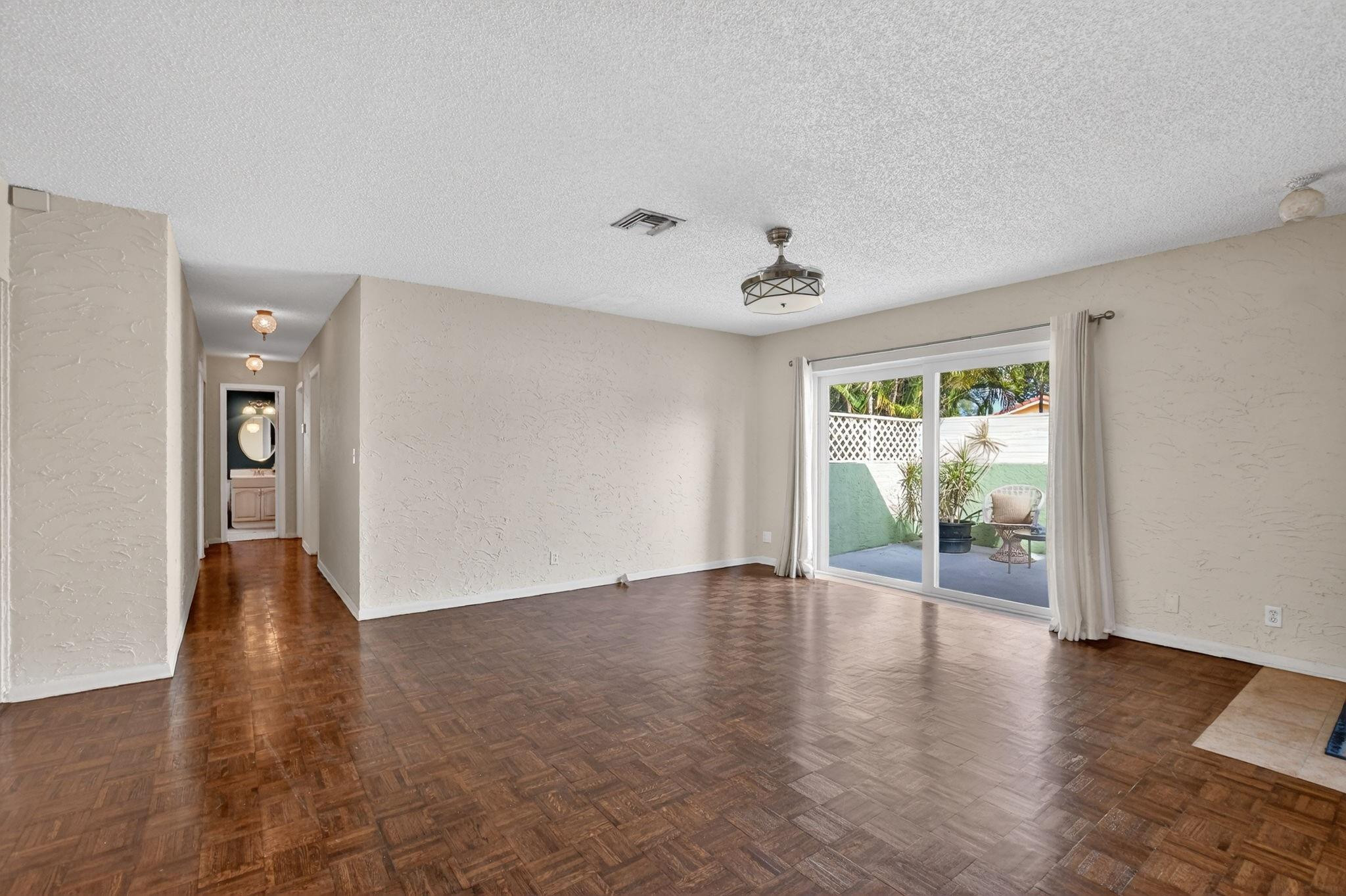 501 Northwest 54th Street Boca Raton, FL 33487 - Photo 7 of 44 a view of an empty room with wooden floor and a window